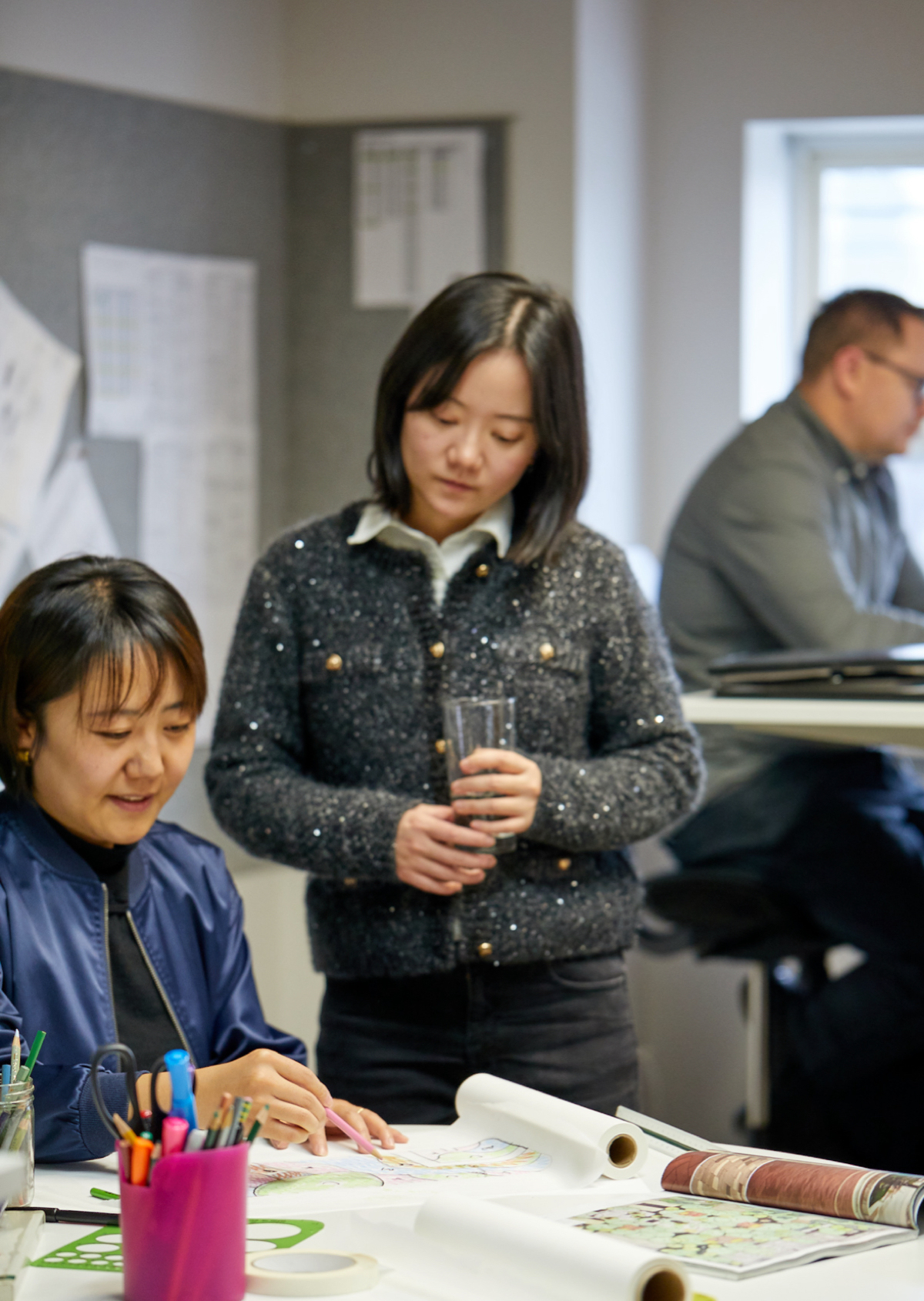 office scene with one worker looking over the shoulder of another